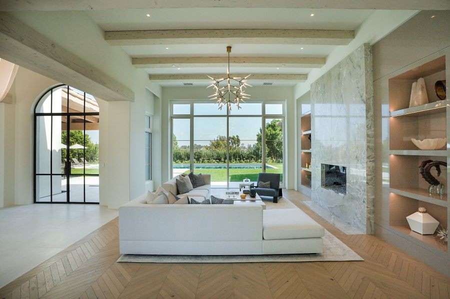 A living room with a view of the pool and in-ceiling lights and speakers.  